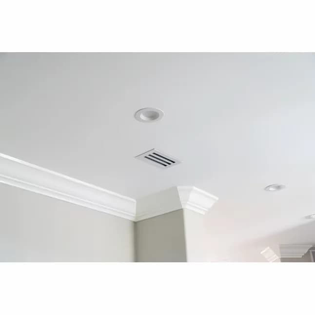 Recessed mini split — a slim flush grille set into a finished white ceiling with crown molding, the only visible sign of the hidden unit above